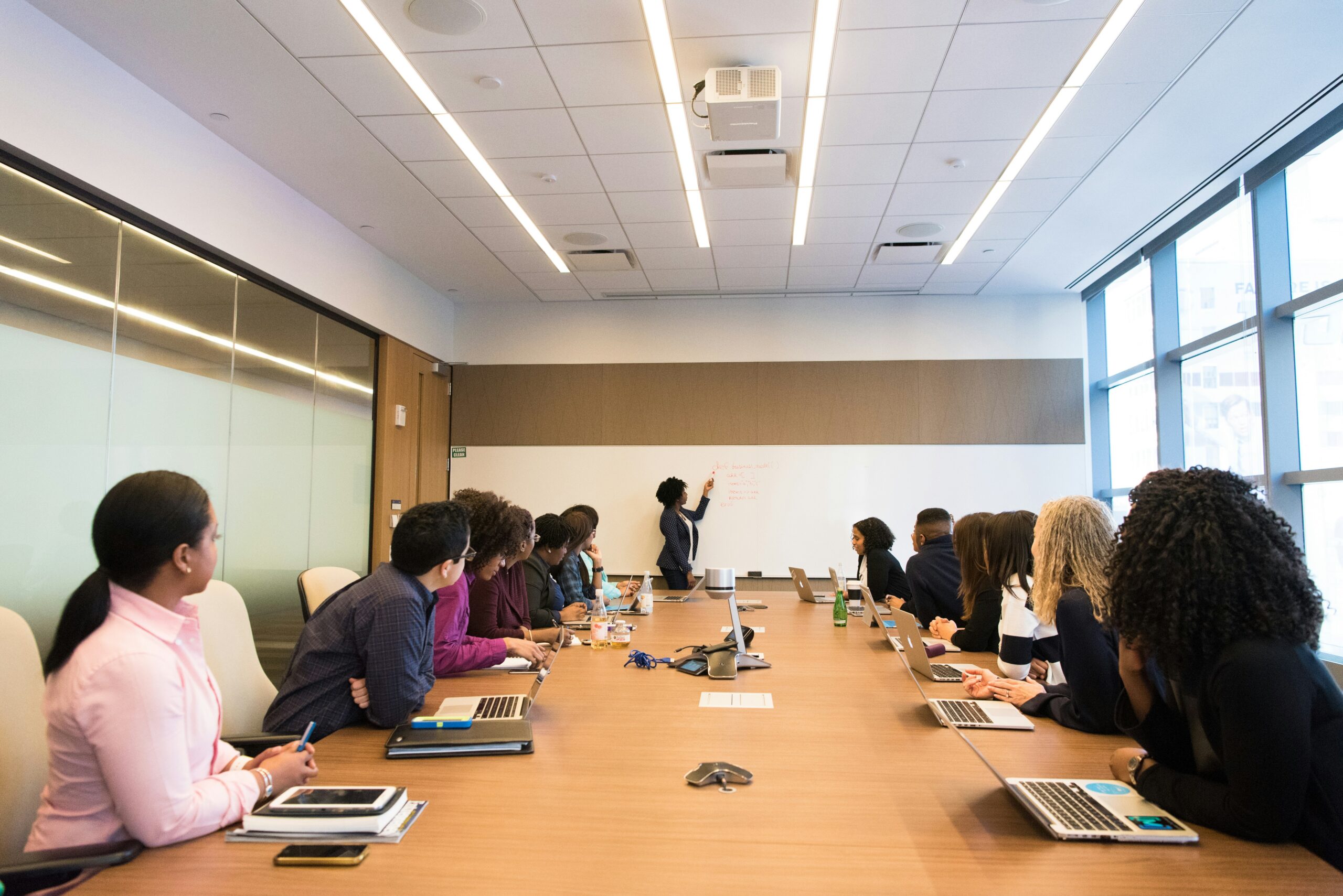 A manager explains a reorganization to employees in a conference room